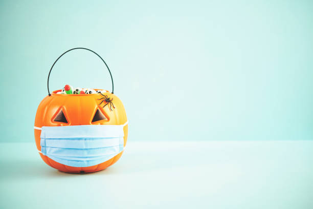 istock Jack O' Lantern Bucket Wearing Face Mask for Halloween 1344689299