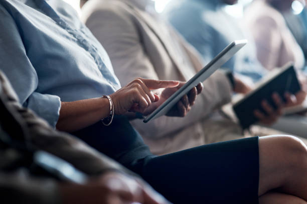 istock Shot of a group of unrecognizable businesspeople using digital tablets and notepads during a conference 1344689442