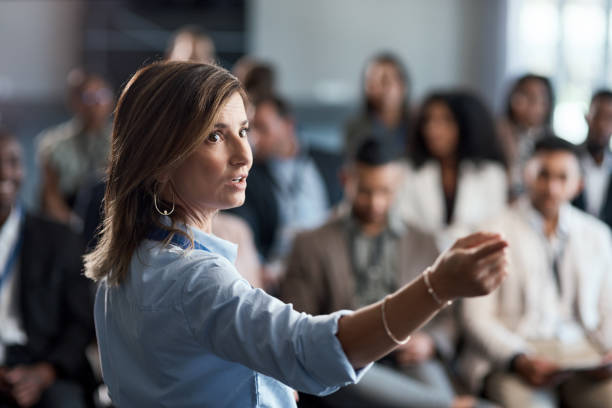 shot of a businesswoman delivering a presentation at a conference - leidinggevende stockfoto's en -beelden