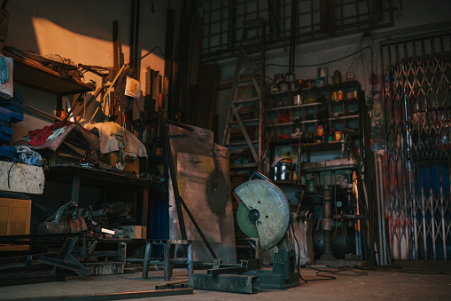 rustic old messy workshop without people illuminated by sunset lighting