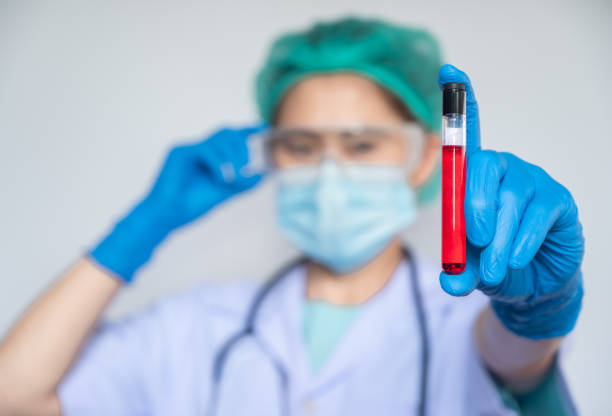 Healthcare worker holding a blood test tube in her hand. A test tube is a glass container used in a scientific laboratory. blood bank stock pictures, royalty-free photos & images