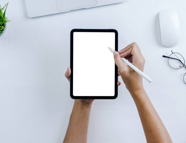 рука с помощью стилуса на мини-цифровом планшете на белом фоне стола - ipad mini ipad white small стоковые фото и изображения