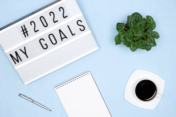 istock Plans for the coming 2022 year concept. Notepad, pen, coffee cup, lightbox with My Goals text on blue desk. Neat workplace 1344693921