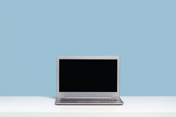 istock Laptop with black mockup screen on white desk blue background 1344693936