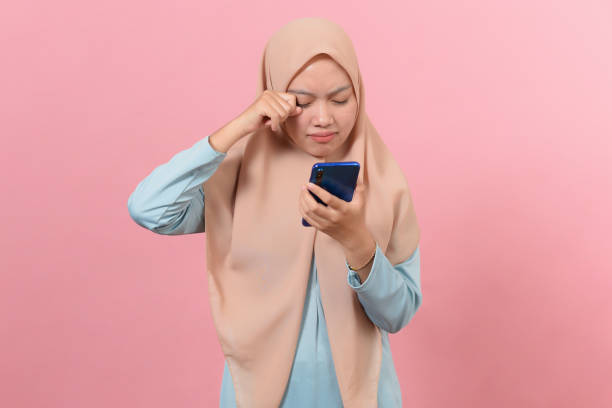 istock Young Muslim Female cry looking at smartphone 1344694010