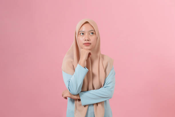 istock Young Asian muslim woman looking at a copy space or thinking an idea 1344694636