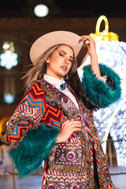 lumières de noël dans la ville, fille blonde caucasienne dans un chapeau à côté d’une boule géante illuminée, style de vie hivernal, photo verticale - women relaxation tranquil scene elegance photos et images de collection