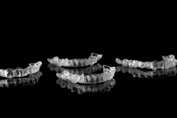 istock Invisible orthodontics cosmetic brackets on black background, tooth aligners, plastic braces. Modern teeth retainers created on a 3d printer. A way to have a beautiful smile and white teeth 1344696095