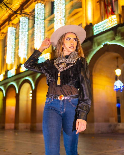 stile di vita invernale, ragazza bionda caucasica che indossa jeans e una giacca nera in città illuminata per natale di notte - yoga winter urban scene outdoors foto e immagini stock