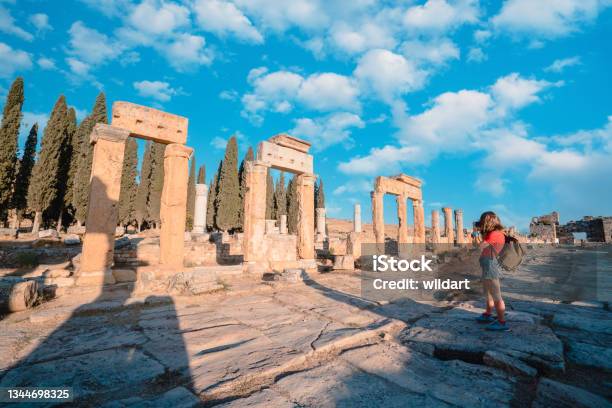Photographer Tourist Girl Is Taking Photos Of The Frontinus Gate In Ancient Ruins Of Hierapolis Pamukkale Stock Photo - Download Image Now