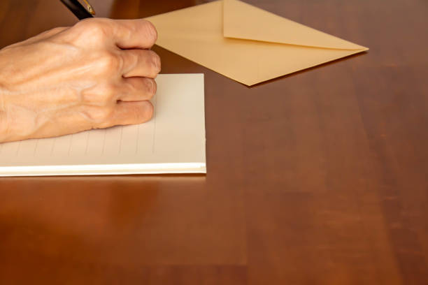 istock Hands holding stationery, envelopes, ballpoint pens, coffee and pens placed on the table 1344703901
