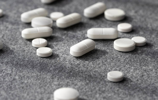 istock close-up white pill on gray background among others. Scattered medicines 1344703926