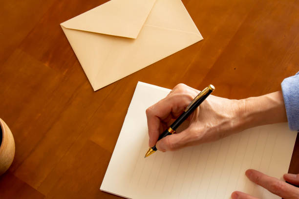 istock Hands holding stationery, envelopes, ballpoint pens, coffee and pens placed on the table 1344704035