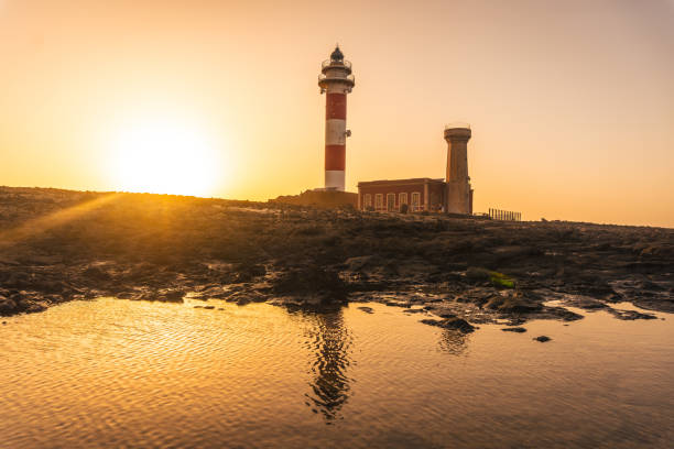 coucher de soleil au phare de toston près de la mer avec le phare réfléchi, punta ballena près de la ville d’el cotillo, île de fuerteventura, îles canaries. espagne - cotillo fuerteventura spain tourism photos et images de collection