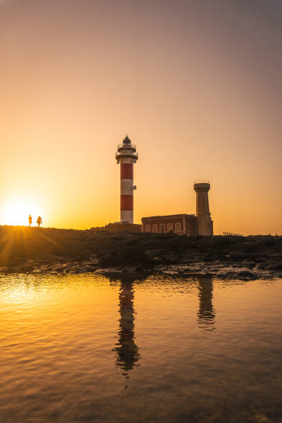 silueta una pareja en la puesta de sol en el faro de toston, punta ballena cerca de la ciudad de el cotillo, isla de fuerteventura, islas canarias. españa - el cotillo fotografías e imágenes de stock