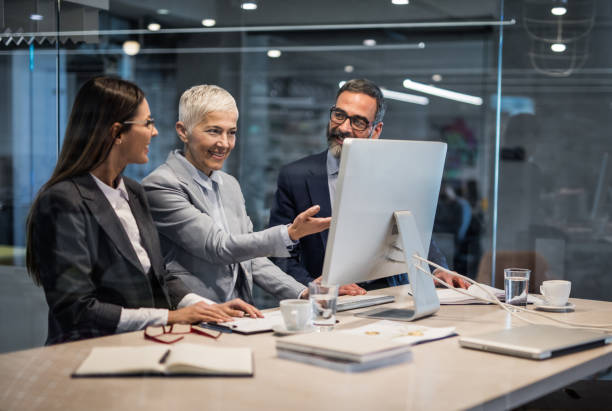istock Group of happy business people working on desktop PC in the office. 1344708202