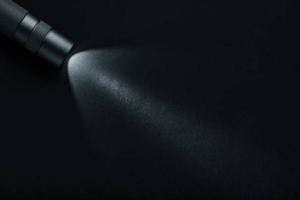 istock Black flashlight with a beam of light on black background 1344714593
