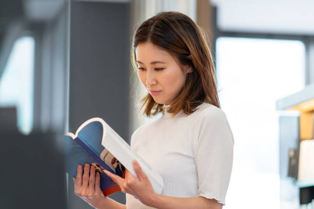 istock Mid adult female reading in the library 1344715468