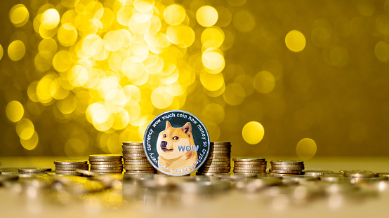 Fujian, China - August 26, 2021: Heap of Dogecoin on shiny golden background.