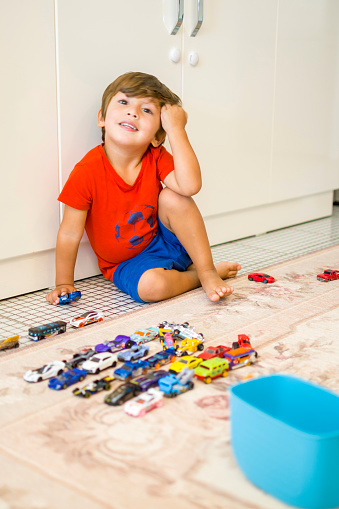 Cute little boy playing with his cars