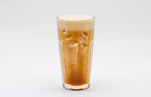 Iced coffee with milk and ice cube isolated white background