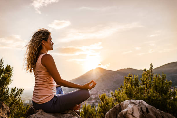 istock Young woman preforms yoga in mountains at sunset 1344718231