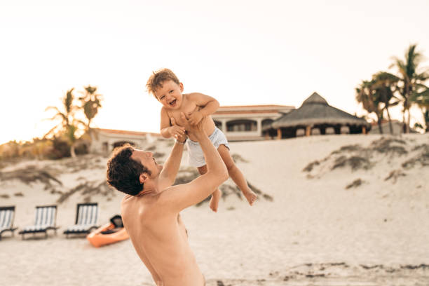 padre e figlio in spiaggia in messico - acapulco mexico sunset day foto e immagini stock