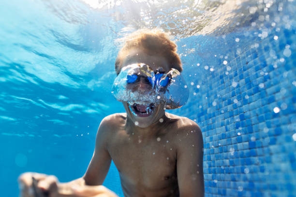 istock Teenage boy in pool shouting underwater 1344719185