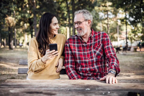 istock Mature couple enjoying in the park and using a smartphone 1344720646