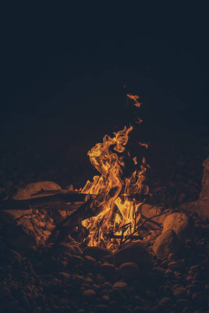 istock Young women relaxes by beach fire at night 1344722610