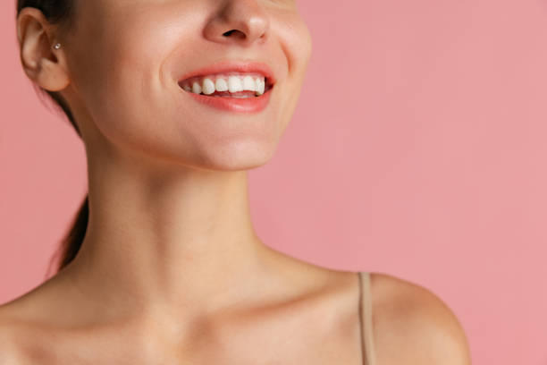 Close-up cropped face of young beautiful girl without makeup isolated over pink studio background. Natural beauty concept. Open smile. Close-up cropped face of young beautiful girl without makeup isolated over pink studio background. Wellness, wellbeing, fitness, cosmetics, well kept skin concept. Proper facial features thin neck stock pictures, royalty-free photos & images