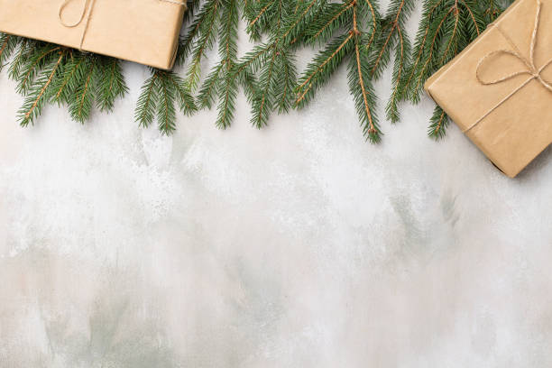 Table with Christmas composition with gift, decorations, fir tree branches on wooden background. Flat lay, top view