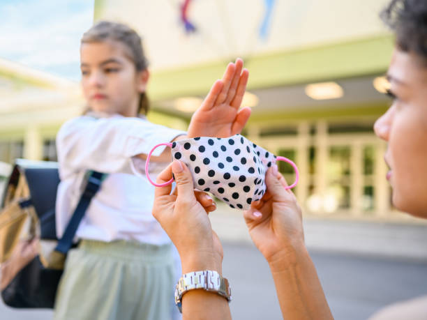 istock Little girl refuse wearing her protective mask 1344726854