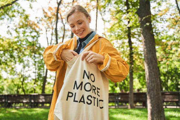 istock Woman taking something from her eco bag while standing at the park 1344726880