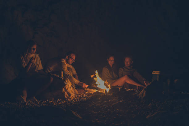 istock A group of friends relax by anbeach fire at night 1344728094