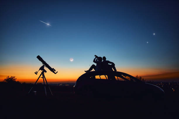 istock Couple stargazing together with a astronomical telescope. 1344728514