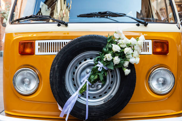 Warsaw, Poland - September 1, 2018: Orange iconic hippie Volkswagen van decorated with bouquets for a wedding in the old town of Warsaw, Poland