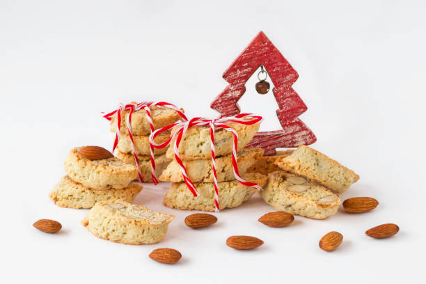 tradycyjne włoskie ciasteczka - cantucci lub biscotti z migdałowymi i czerwono-białymi ozdobami świątecznymi na białym tle. - biscotti isolated cantucci almond zdjęcia i obrazy z banku zdjęć