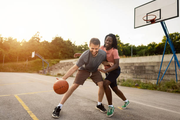 istock Active multiracial couple spending their weekend together, playing pickup basketball 1344733436