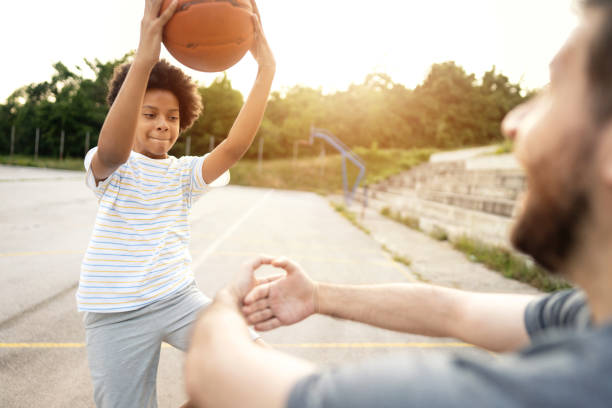istock Proud father, supporting and cheering his daughter while she trying to dunk into imagined hoop her father made with his hands 1344733539
