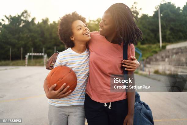 Proud Mother Of Black Ethnicity Picking Up Her Teenage Daughter From Her Basketball Practise Stock Photo - Download Image Now
