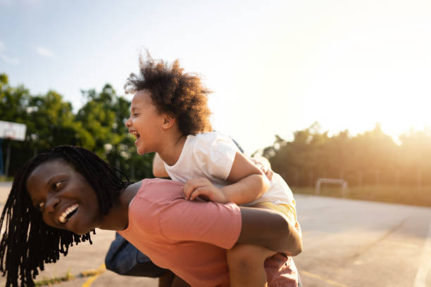 istock Joyful daughter enjoying a day with her mother, while piggyback her 1344733650