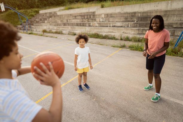 istock Mother teaching her curious and active daughter basic of basketball 1344733713