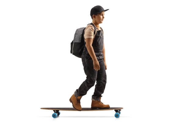 istock Full length profile shot of a boy with a backpack riding a longboard 1344734117