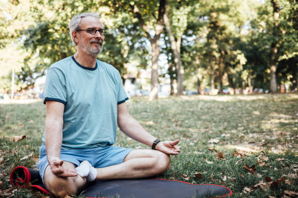 istock Mature man meditating in the park 1344734661