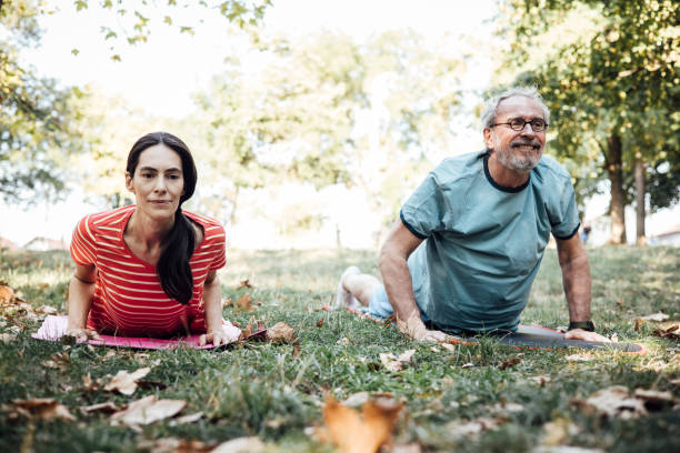 istock Couple doing yoga practice in the park 1344734665