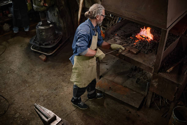 istock Craftsman adding coal in the furnace 1344735365