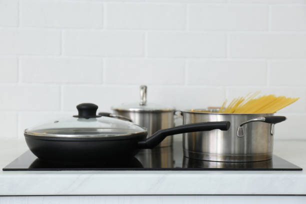 istock Pot with uncooked pasta and frying pan on stove in kitchen 1344739040