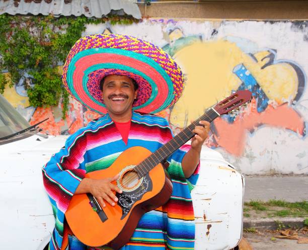 istock Mexican humor man smiling playing guitar sombrero 1344739120