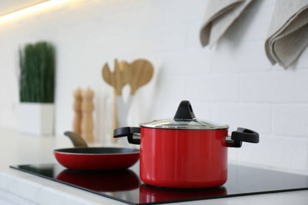 istock Red pot and frying pan on stove in kitchen 1344740730